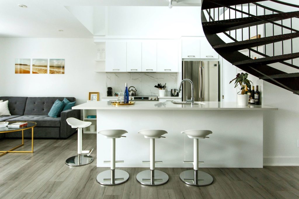 Expansive white living space paired with a bunch of similarly white swivel barstools
