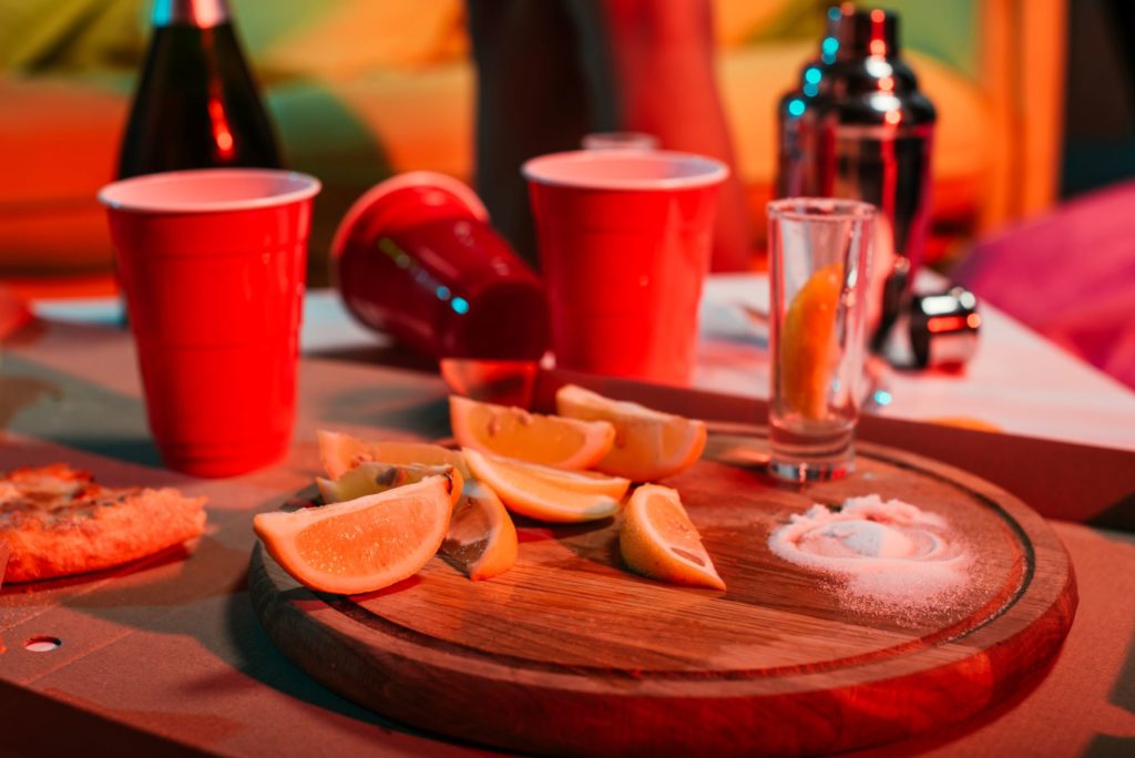 Plastic red cups on a messy table with salt and lemon slices